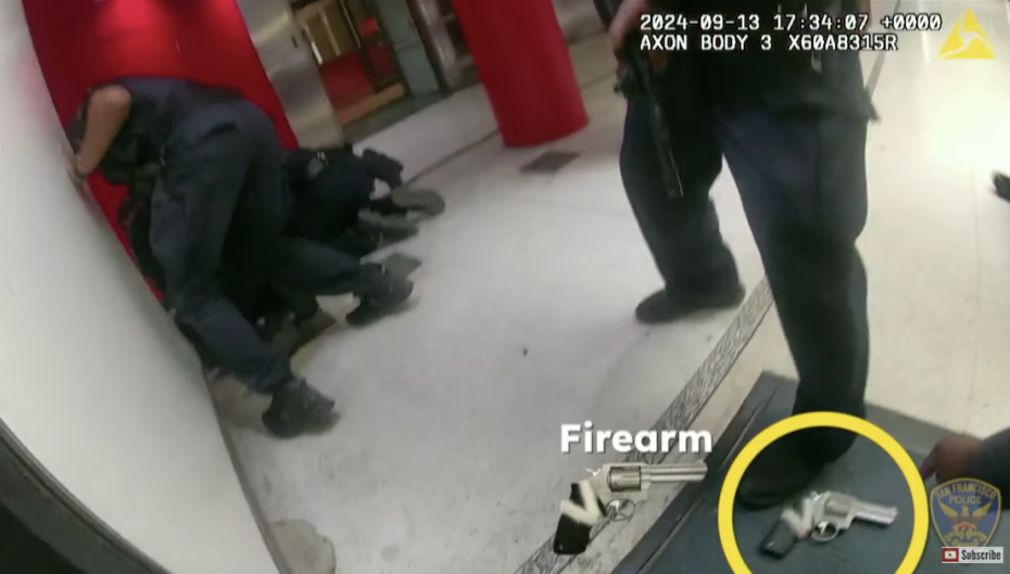 Body cam footage shows officers detaining a person on the ground next to a wall. A handgun on the floor is circled and labeled "Firearm" at the bottom right corner of the image.